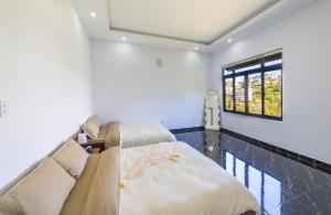 a living room with two beds and a window at Cocovilla Đà Lạt in Ấp Ða Lợi