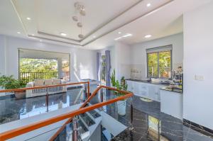 a kitchen with white walls and a glass counter top at Cocovilla Đà Lạt in Ấp Ða Lợi