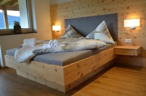 a bedroom with a wooden bed with pillows on it at Ferienwohnung La-Wurm mit privatem Whirlpool in Hart im Zillertal