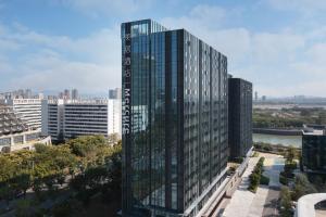 eine Luftansicht eines hohen Glasgebäudes in der Unterkunft Mercure Xiamen Science City in Xiamen