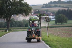 a man driving a golf cart down a road at Ferienwohnungen Eichenhof in Kapellen-Drusweiler