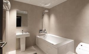 a white bathroom with a tub and a sink at 호텔인카페 파주금촌점 in P'aju