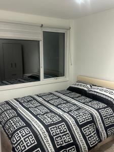 a bedroom with a bed and a large window at Systematic Home in Battlesbridge