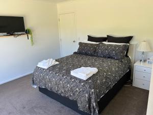 a bedroom with a bed with two towels on it at Cambridge Lodge in Cambridge