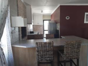 a kitchen with a bar with chairs and a counter top at Magic Flame farm in Hopefield +6 photos