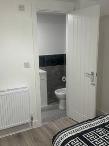a bathroom with a bed and a toilet in a room at Systematic Home in Battlesbridge