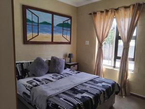 a bedroom with a bed and a large window at Magic Flame farm in Hopefield