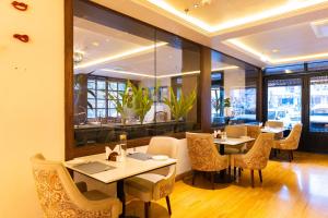 a restaurant with tables and chairs and windows at The Naori by Alaya Stays in Udaipur