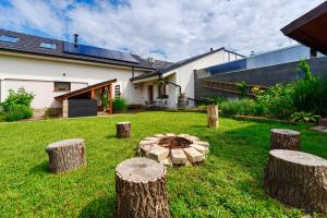 Un jardín con troncos y una fogata en el césped. en Penzion Mikulecký Kutloch, en Mikulčice