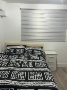 a bedroom with a bed with a black and white comforter at Systematic Home in Battlesbridge