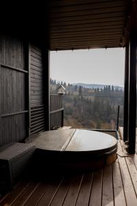 a large window in a room with a table on a deck at Ecottage котедж для двох у горах із чаном-джакузі in Slavske