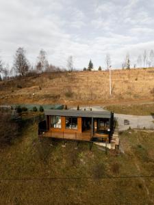 eine Aussicht auf ein Haus auf einem Feld in der Unterkunft Ecottage котедж для двох у горах із чаном-джакузі in Slawske
