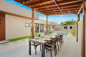 een eettafel en stoelen op de patio van een huis bij Aruba Escape Spacious 5BR Villa for 12 by Bocobay in Oranjestad