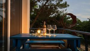 een blauwe tafel met glazen en een fles wijn bij Ganghwado Happyvilly Pension in Incheon