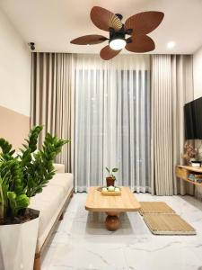 ein Wohnzimmer mit einer Couch und einem Deckenventilator in der Unterkunft Jane's Cozy Home in Gò Công