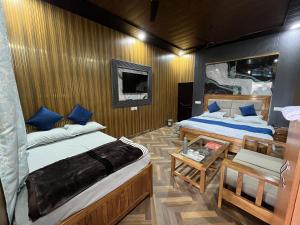 a small room with two beds and a table at Magic Restaurant Hotel in Haldwāni