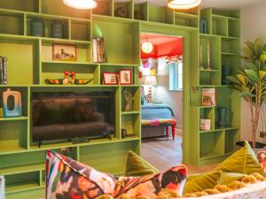 uma sala de estar com prateleiras verdes e uma tv em The Twitcher - Uk50612 em Appletreewick