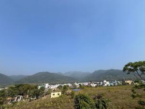 a town on a hill with mountains in the background at Magic Restaurant Hotel in Haldwāni