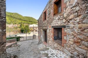 een oud stenen gebouw met een raam op een straat bij Cal Marti in Farena