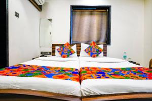 a bedroom with two beds with colorful sheets at Hotel O Shalimar in Mumbai
