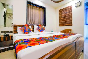 a bedroom with a large bed with a colorful comforter at Hotel O Shalimar in Mumbai