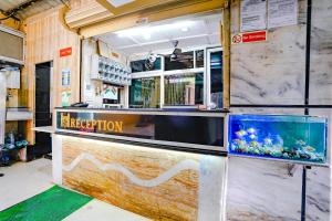 a restaurant with a counter with a fish tank at Hotel O Shalimar in Mumbai