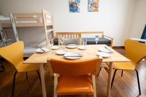 un tavolo da pranzo con sedie e un tavolo di legno con bicchieri di Furano Zone Ski Condo 202喫煙可103禁煙 a Furano