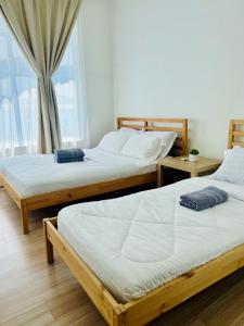 three beds in a room with a window at Luxury 2BR at Heart of Melaka in Melaka +34 photos