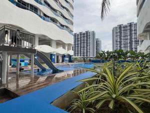 a swimming pool with a slide in the middle of two buildings at Luxury 2BR at Heart of Melaka in Melaka