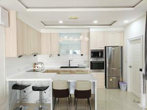 a kitchen with a white counter and a refrigerator at 3BR Pool Villa Beach Access Patumnak Hill in Pattaya South
