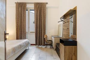 una habitación de hotel con una cama y un televisor en Villa Giove alla stazione - Prato, en Prato