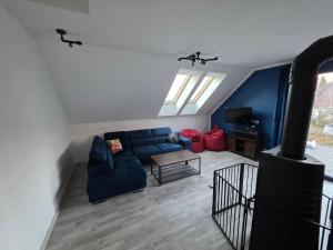 ein Wohnzimmer mit einem blauen Sofa und einem Herd in der Unterkunft Domki Przystankowe 4 żywioły in Smerek