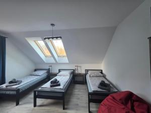 ein Zimmer mit drei Betten und einem Dachfenster in der Unterkunft Domki Przystankowe 4 żywioły in Smerek