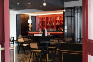 a restaurant with tables and chairs and a bar at Grey Parrot Resort Hotel in Chengdu