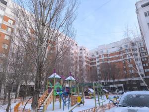 a playground covered in snow in a city at Апартаменты на Бараева in Astana