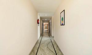 a hallway with white walls and a picture on the wall at Treebo Golden Leaf DDN in Dehradun