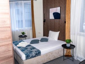 1 dormitorio con 1 cama con 2 mesas y 2 ventanas en City House Family Hotel & Restaurant, en Ruse 79 fotos más