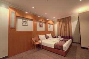een hotelkamer met een bed en een stoel bij فندق المغاربي للشقق الفندقية 3 in Al Madinah +67 foto's