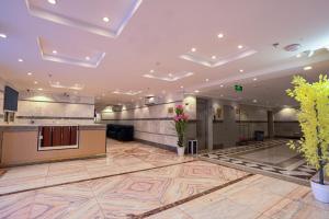 een lobby van een hotel met een receptie en bloemen bij فندق المغاربي للشقق الفندقية 3 in Al Madinah