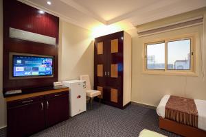 een hotelkamer met een bed en een televisie bij فندق المغاربي للشقق الفندقية 3 in Al Madinah