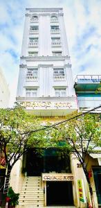 a tall white building with stairs in front of it at ORANGE Hotel - near Dragon Bridge & the Cathedral, in the Heart of the City, Warm as Home in Da Nang