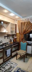 a kitchen with a stove and a chair in it at Апартаменты на Бараева in Astana
