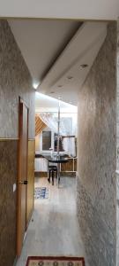 a hallway with a dining room with a table and a room at Апартаменты на Бараева in Astana