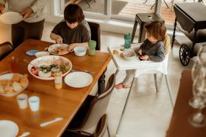 eine Gruppe von Kindern, die an einem Tisch sitzen und Essen essen in der Unterkunft Ecology between forest and river - L'Hermine Charme in Saint-Raymond + 55 Fotos