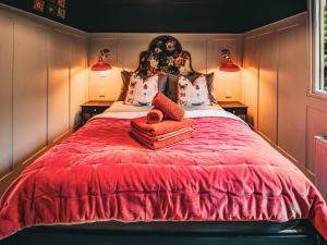 ein Schlafzimmer mit einem großen roten Bett mit zwei Kissen in der Unterkunft The Game Keeper - Uk50611 in Appletreewick