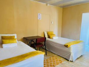 a room with two beds and a table and a chair at Starlight bed and breakfast in Katima Mulilo +18 photos