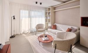 a living room with a couch and a chair and a table at Aminess Younique Vollo Hotel Residences in Opatija +72 photos