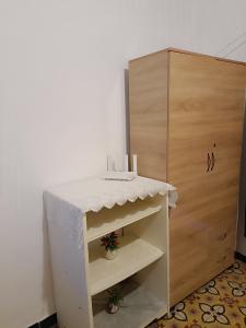 ein kleiner weißer Tisch neben einem Holzschrank in der Unterkunft La coquette de sidi bousaid in Sidi Bou Saïd