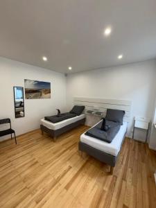 2 letti in una camera con pavimento in legno di Central City Apartment Mozart a Kaiserslautern