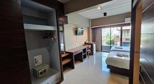 une chambre avec un lit, un bureau et un lavabo dans l'établissement Wsotel Hotel, à Ban Saphan Yao